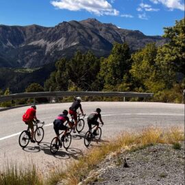 Group of cyclists riding on a road in the Alps